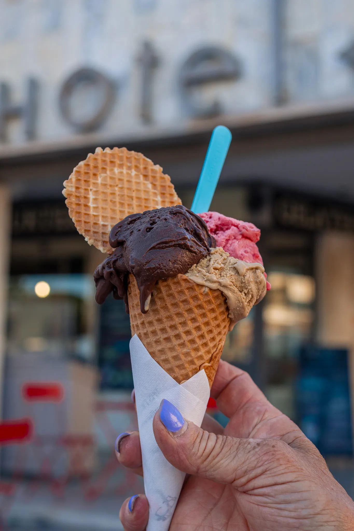 Cono con cioccolato, fragola e crema davanti alla gelateria di Tirrenia