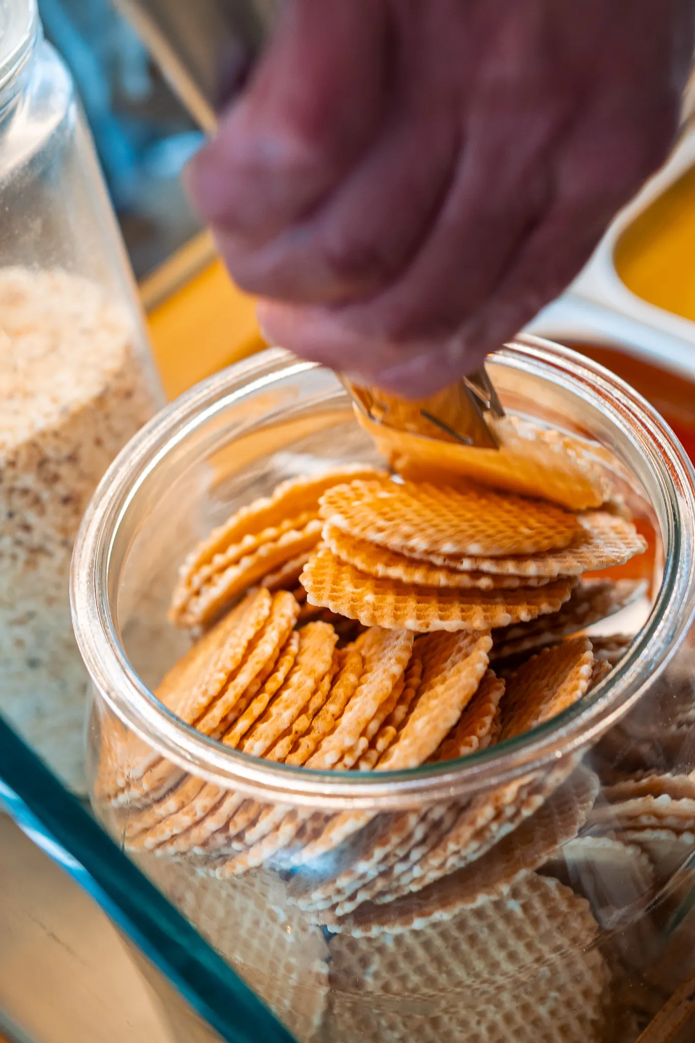 Barattolo di vetro pieno di cialde rotonde dorate appena consegnate