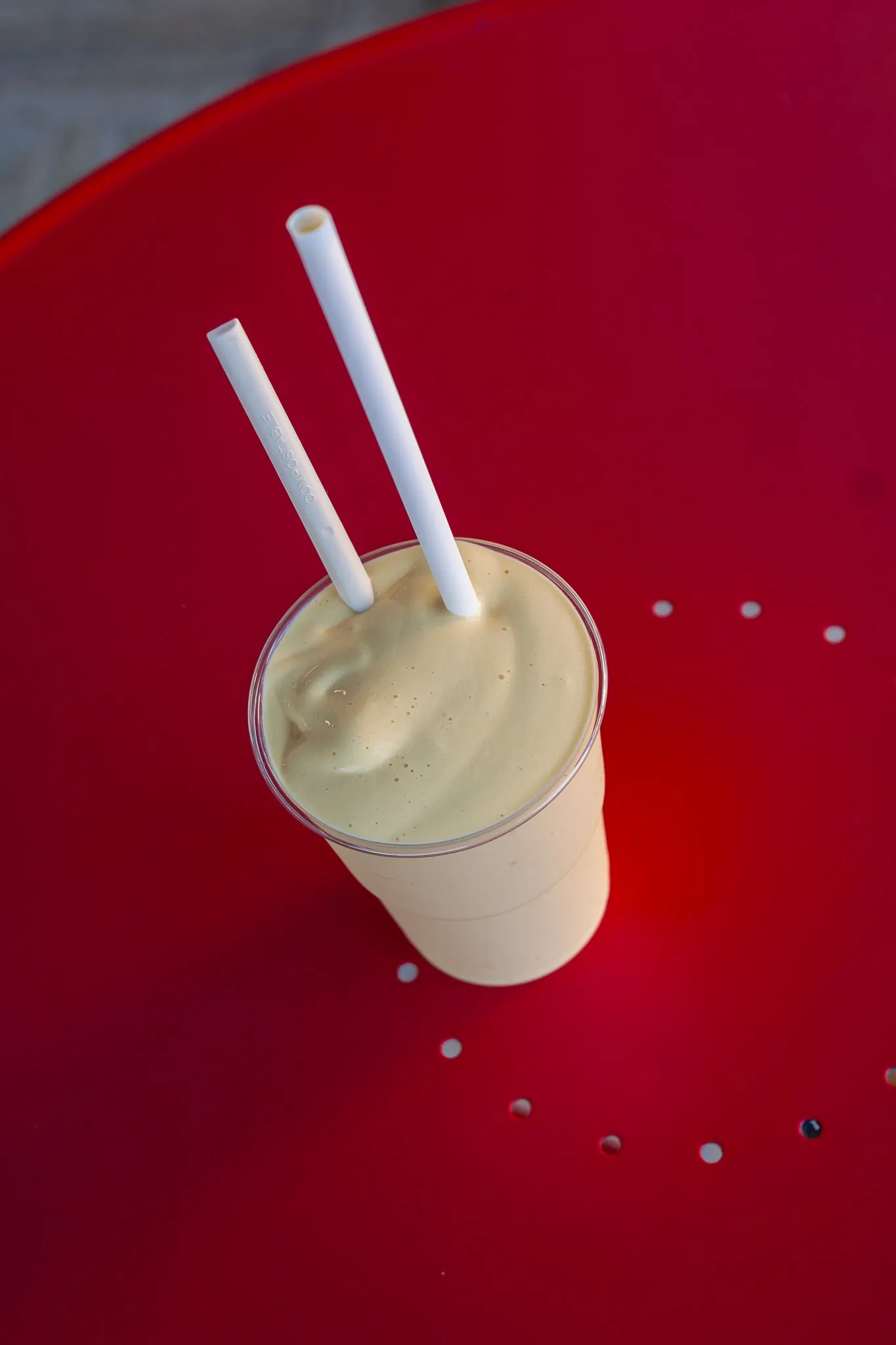 Frullato cremoso con due cannucce su un tavolino rosso